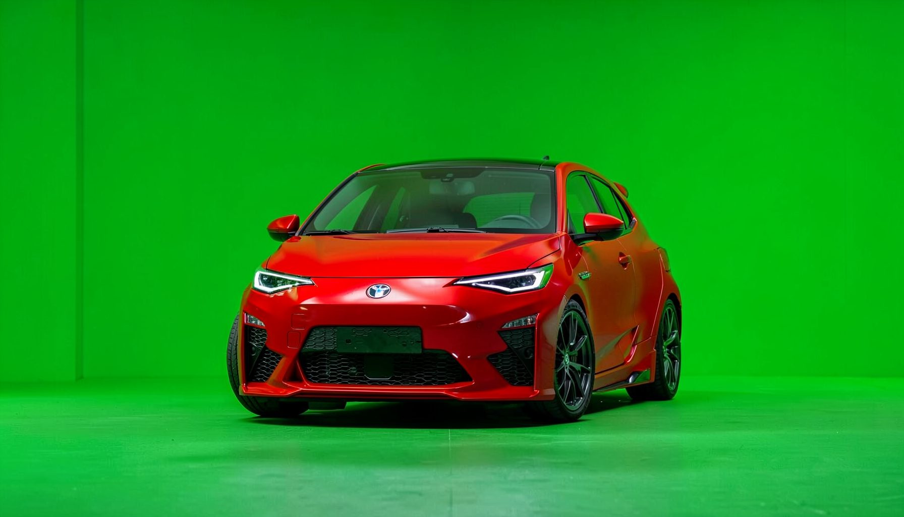 Kırmızı renkli sportif bir hatchback, alçak profilli lastikler ve agresif ön tampon tasarımı.